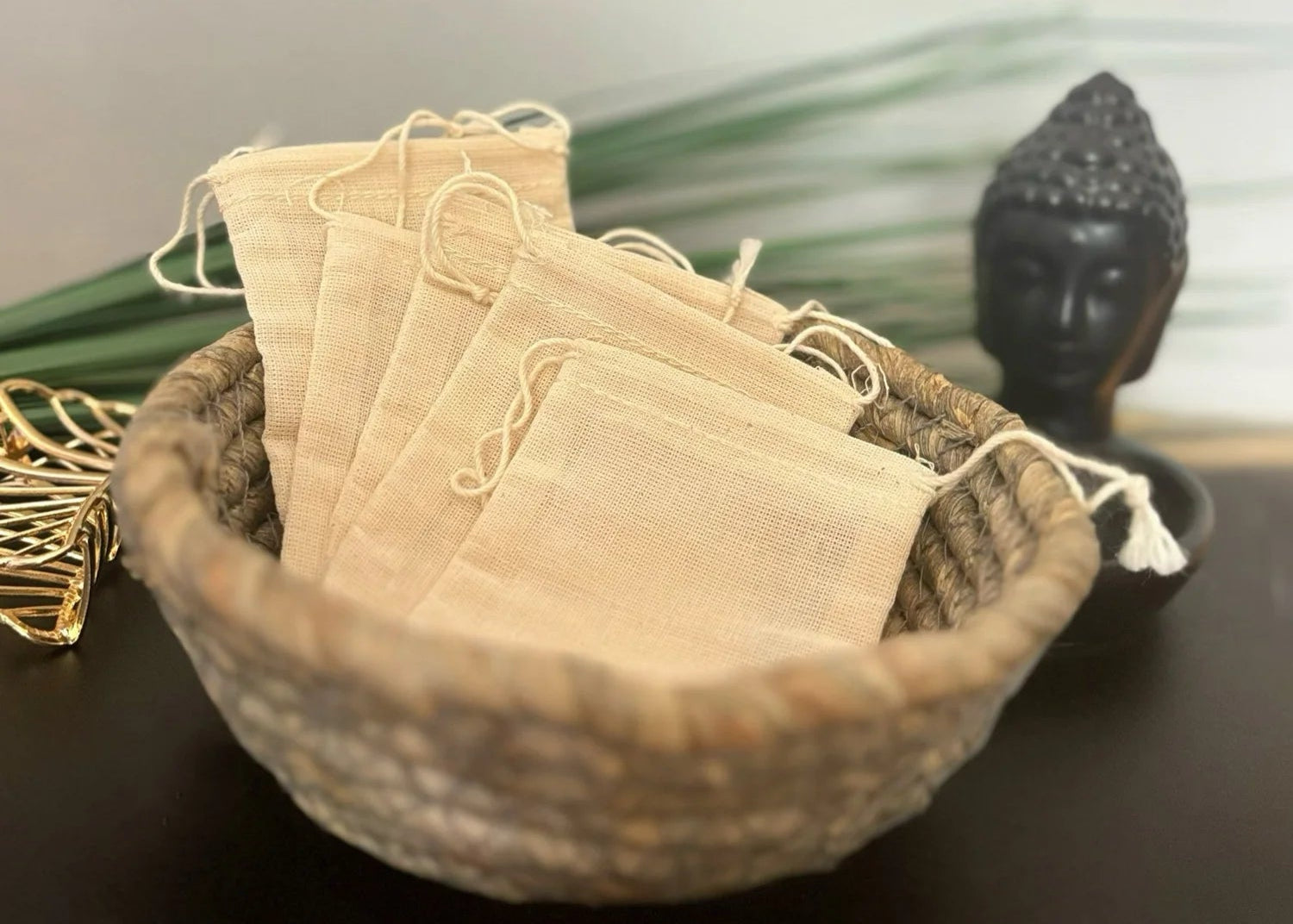 woven Bowl with muslin cloth bags for tea on a dark surface