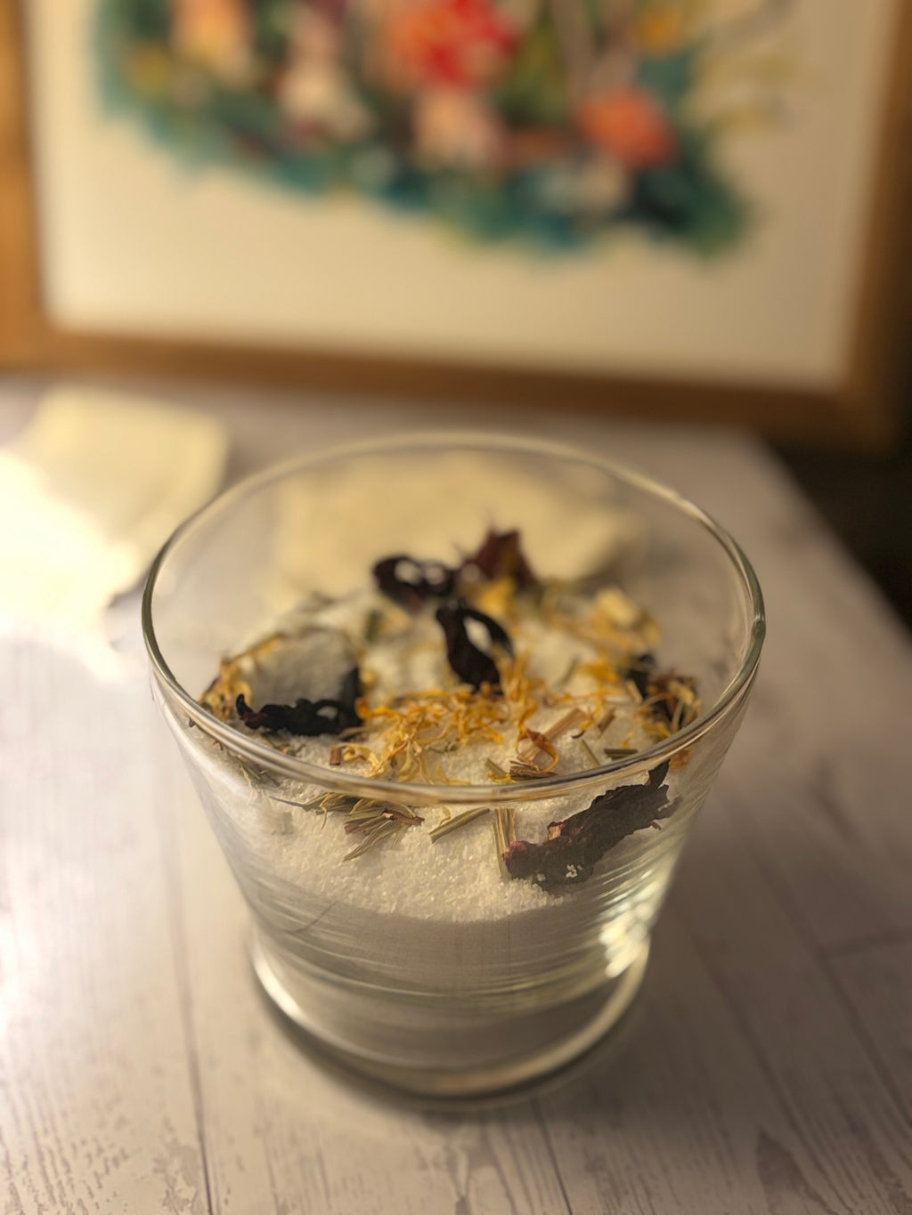 Clear glass bowl with dried herbs on a wooden surface
