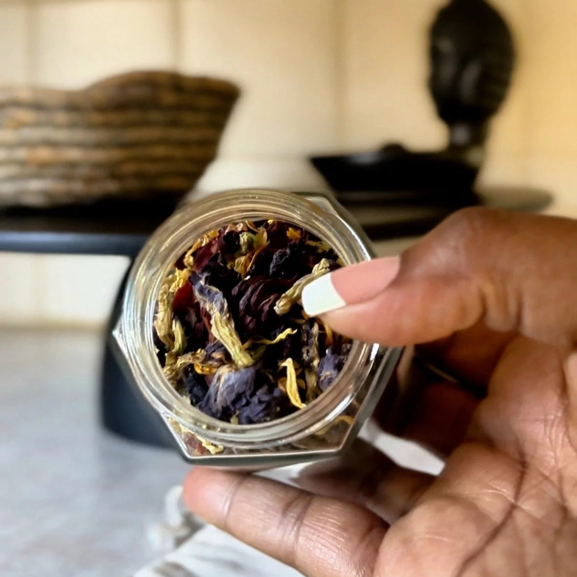 Black woman holding glass jar of organic herbs crafted for tea